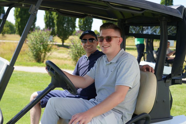2 Maenner in einem Golf Car