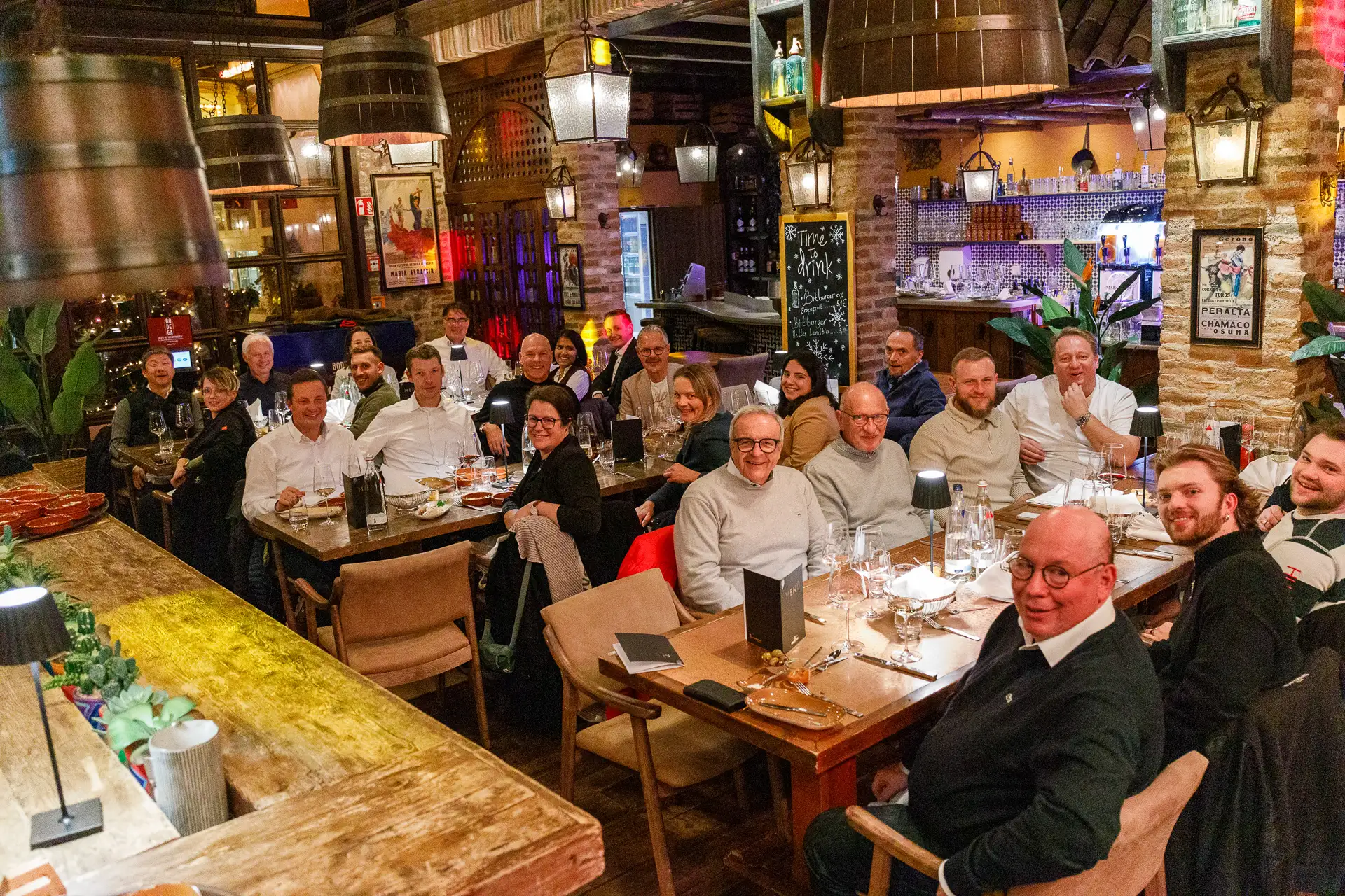 Gruppenfoto in einem Restaurant mit den Teilnehmern an 3 großen Tischen